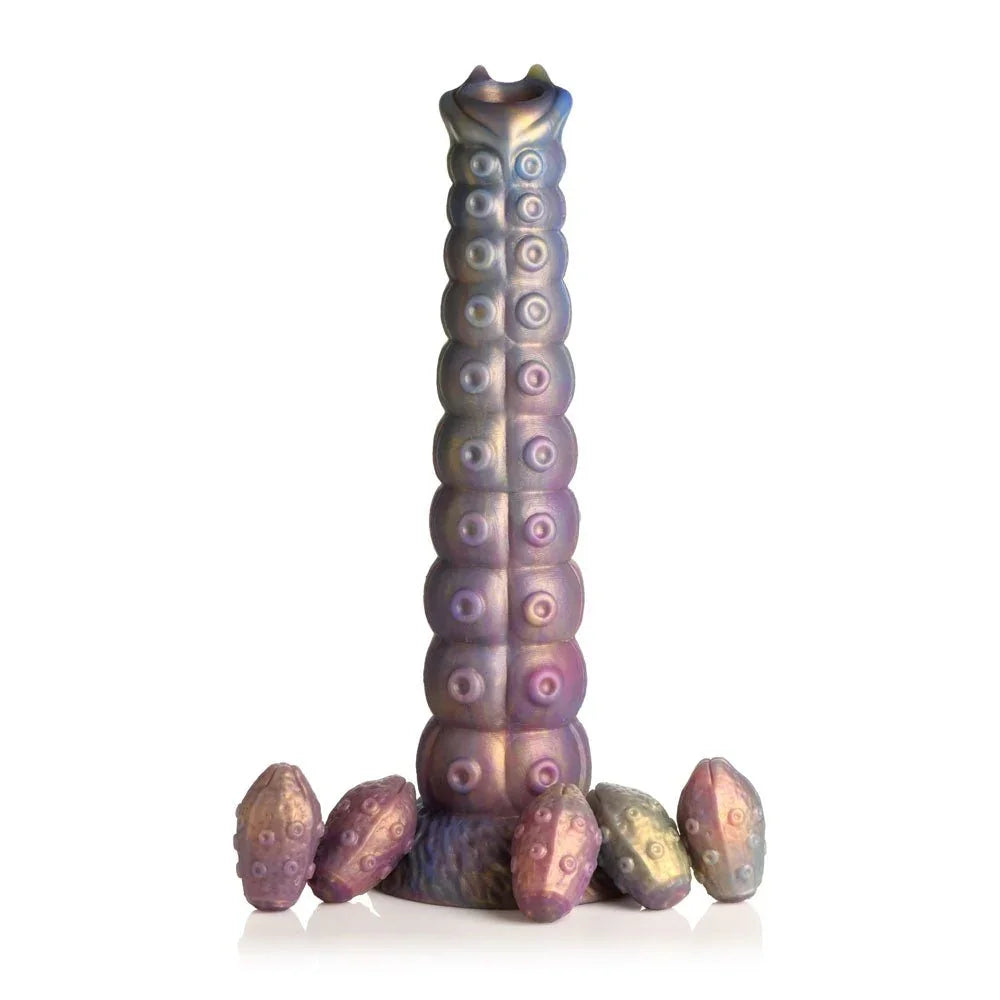 Deep Invader dildo upright on white with the five soft eggs at its base