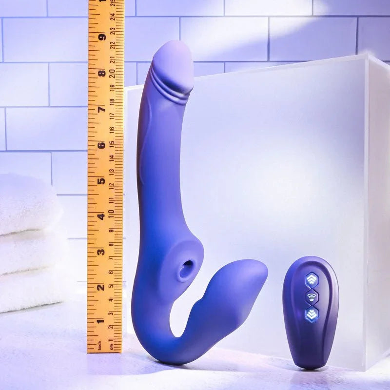Evolved 2 Become 1 in Purple beside a tape measure reading about 9 inches, remote alongside