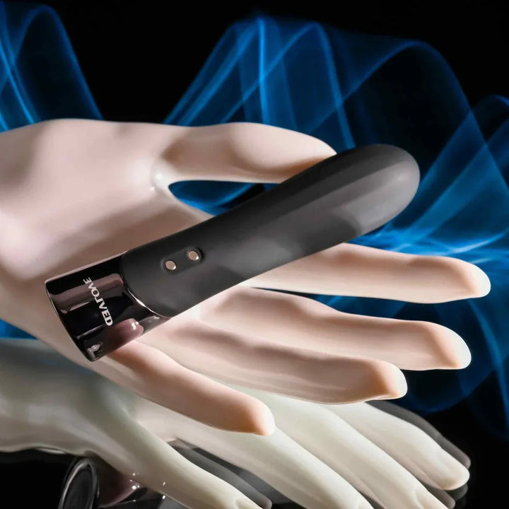 Evolved Back In Black bullet in Black resting across a pale mannequin hand