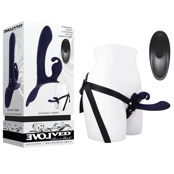 Evolved Giving Vibes retail box beside the navy strap-on harness on a white mannequin hip, remote alongside