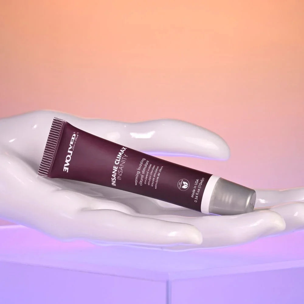 Evolved Insane Climax Insanity tube resting on a glossy white mannequin hand
