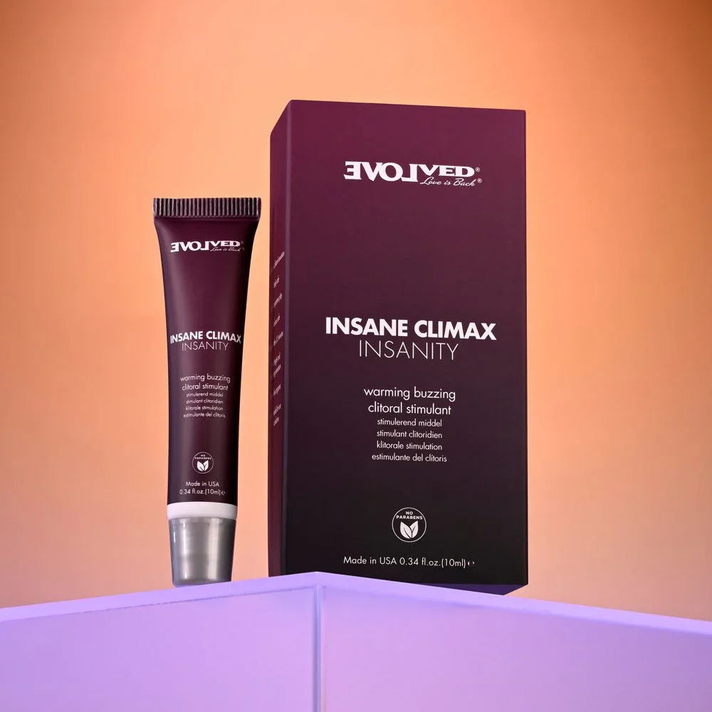 Evolved Insane Climax Insanity tube standing to the left of its plum carton on a lilac ledge