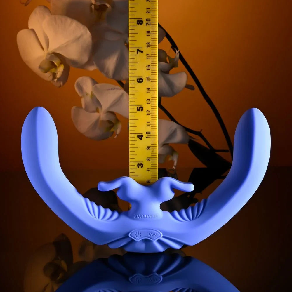 Evolved Lovebirds in periwinkle standing beside an upright tape measure, orchids in the background