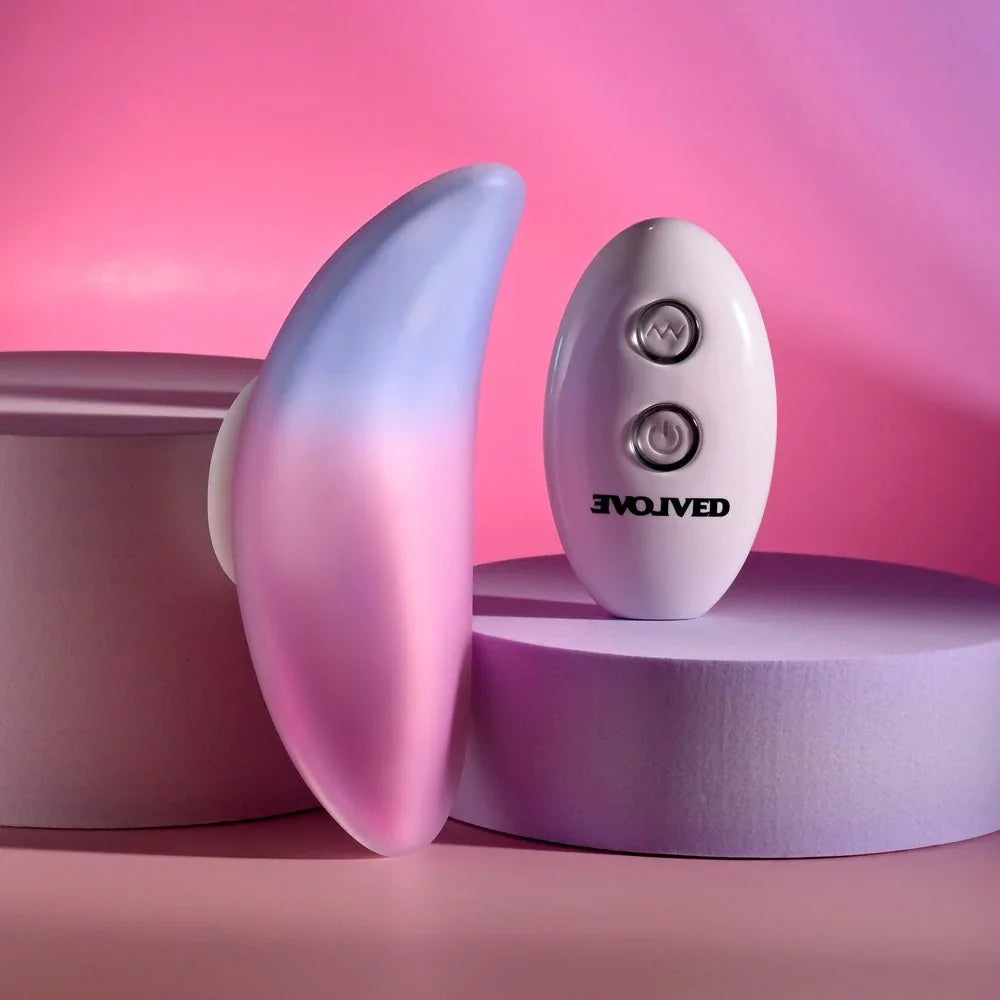 Evolved Paradise Panty in Pink/Purple stood on edge, showing the curved profile, remote beside it