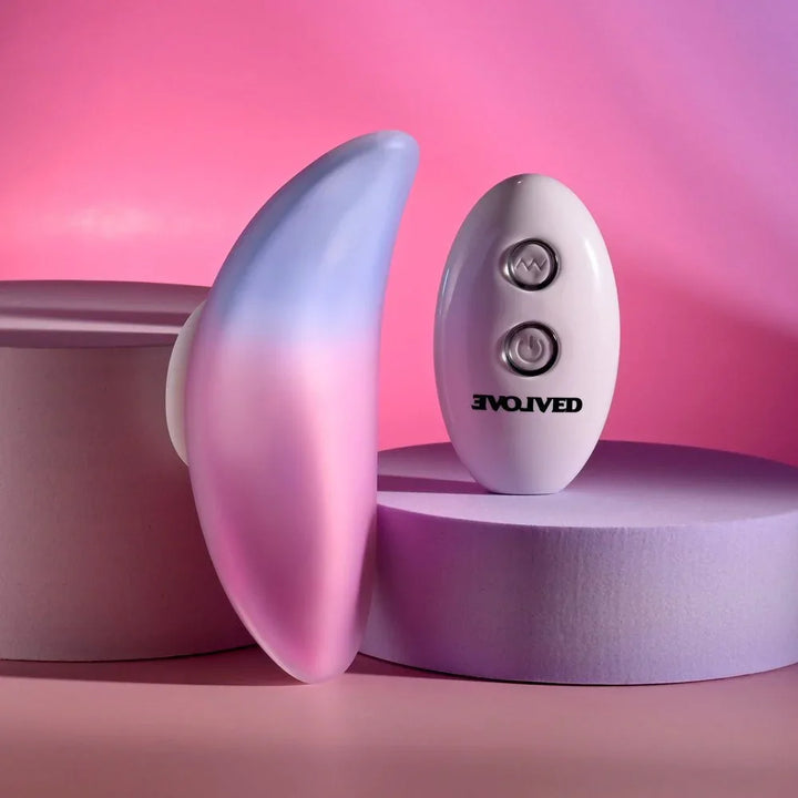 Evolved Paradise Panty in Pink/Purple stood on edge, showing the curved profile, remote beside it