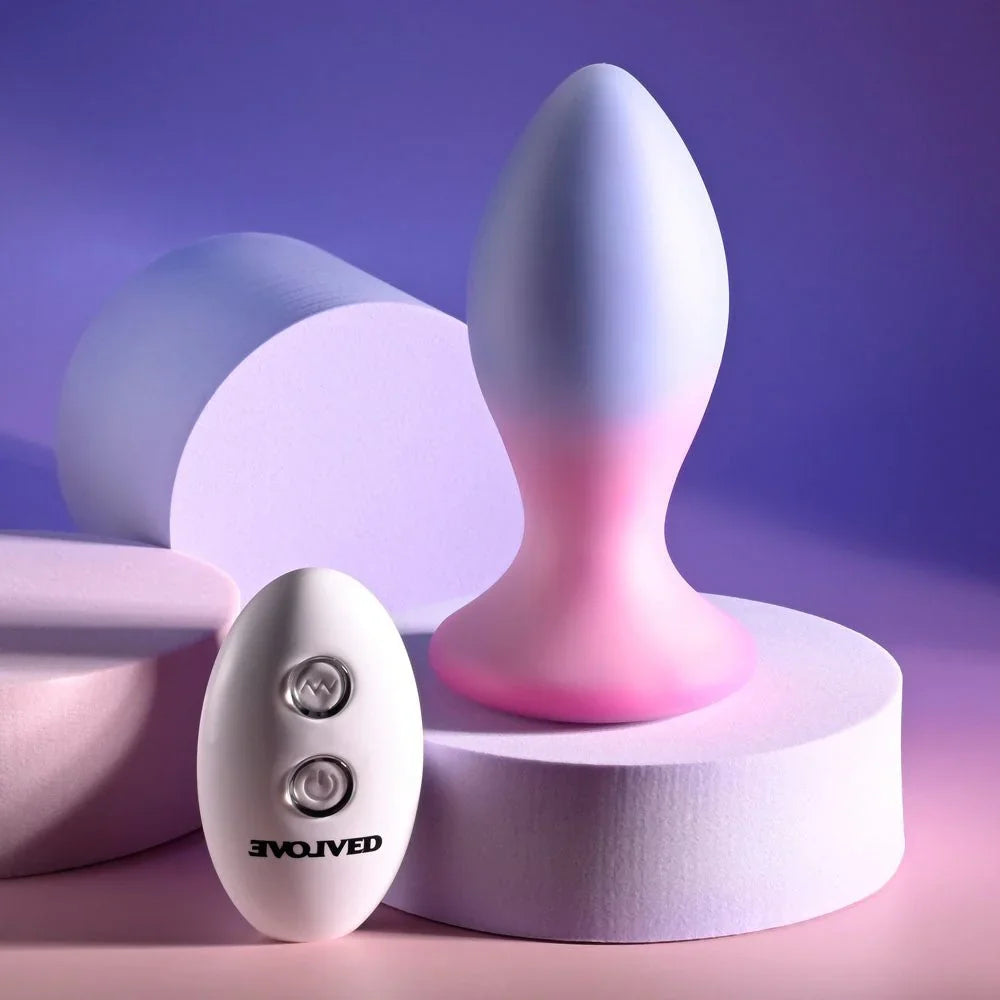 Evolved Paradise Plug in Pink/Purple upright on a podium with the remote low in the foreground