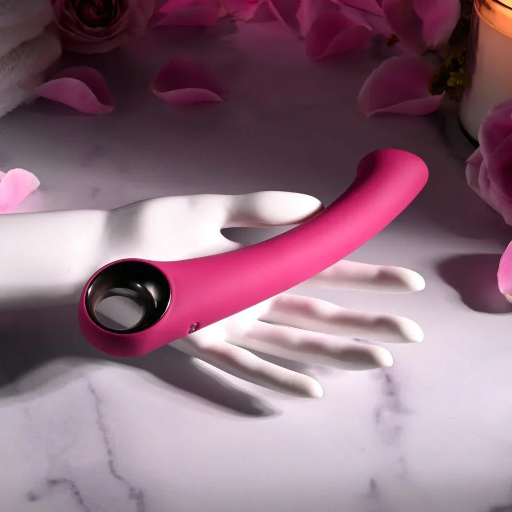 Evolved Pleasure Curve in Pink resting on a glossy white mannequin hand