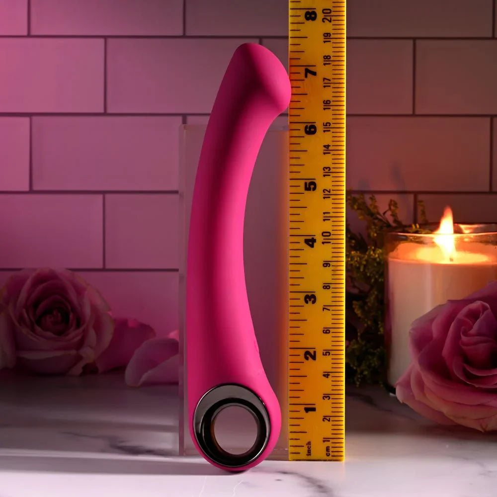 Evolved Pleasure Curve in Pink upright beside a tape measure, reading about 7.5 inches