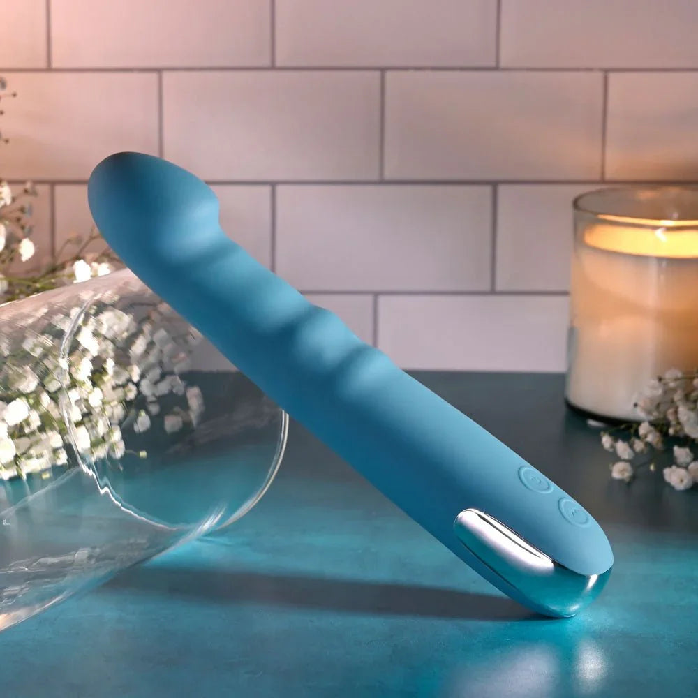 Evolved Queen Of All Trades in teal blue leaning against a toppled glass cylinder