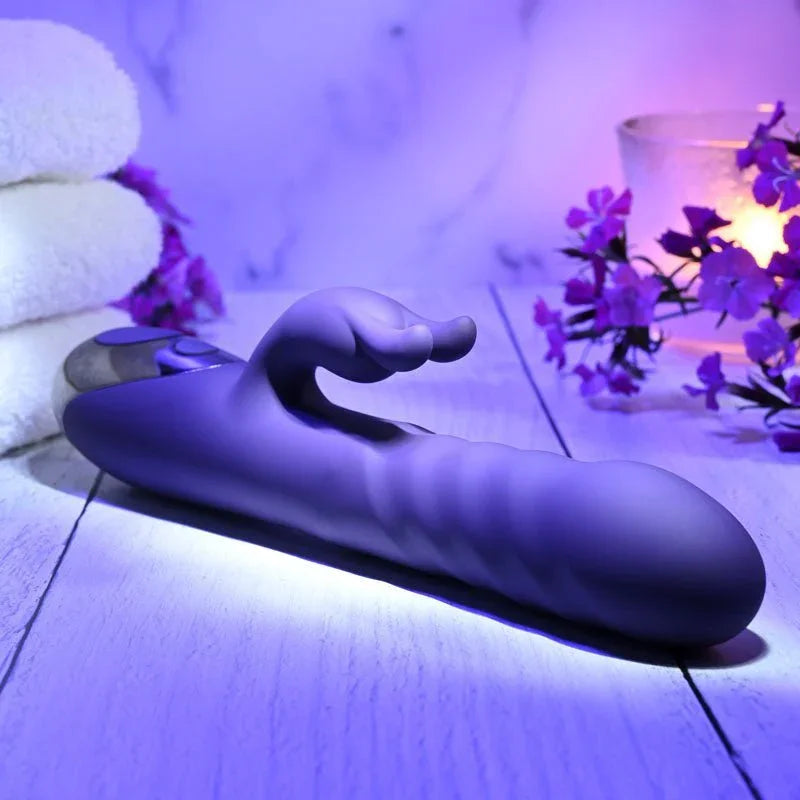 Evolved Rascally Rabbit in Purple lying flat on white boards, purple flowers and candle behind