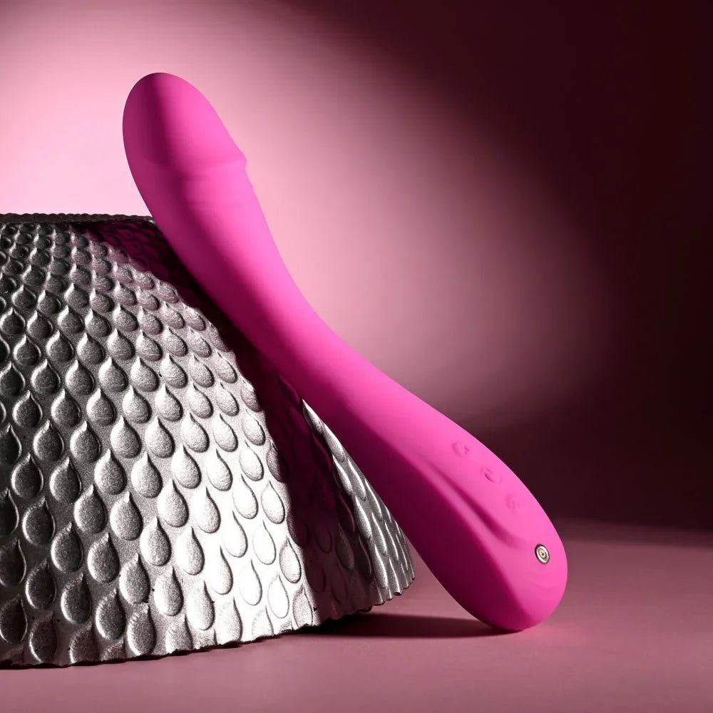 Evolved Sugar Rush in Pink leaning on the silver sphere, tip up to the left, base on the surface