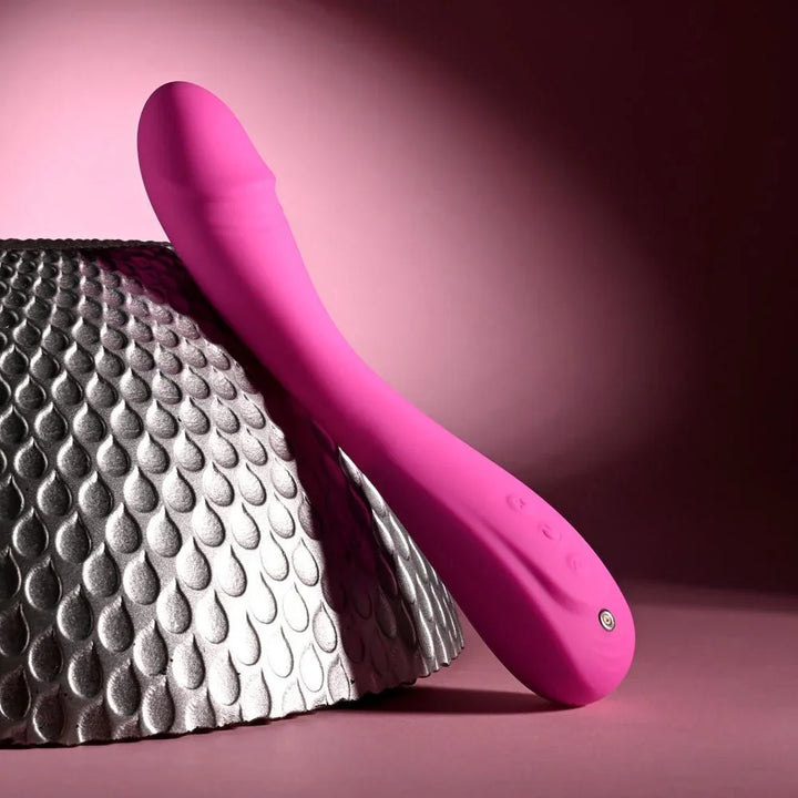Evolved Sugar Rush in Pink leaning on the silver sphere, tip up to the left, base on the surface