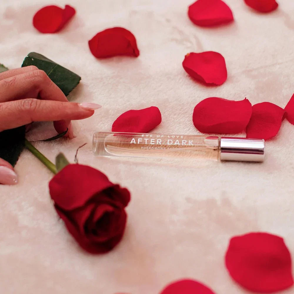 After Dark 10ml vial on pink fabric with a red rose and scattered petals