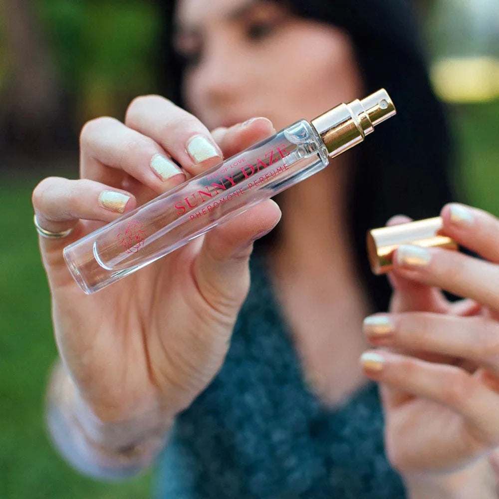 Woman outdoors uncapping the Eye Of Love Sunny Daze 10ml pheromone perfume