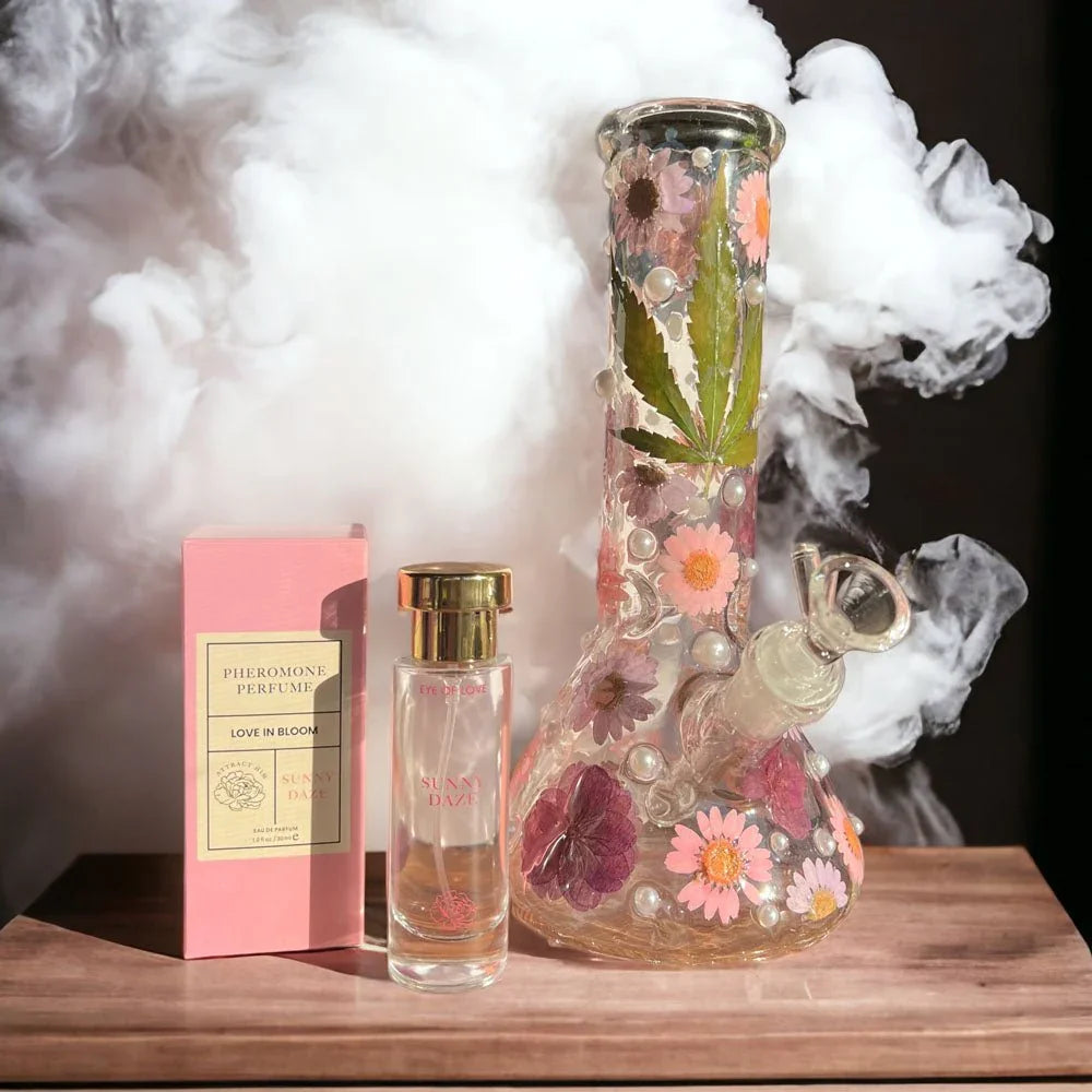 Sunny Daze 30ml bottle and carton on a wooden board beside a flower-set glass water pipe