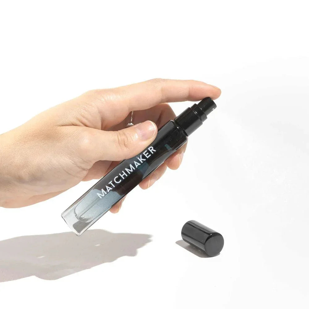 Eye Of Love Matchmaker Black Diamond Cologne 10ml held in a hand, cap resting alongside