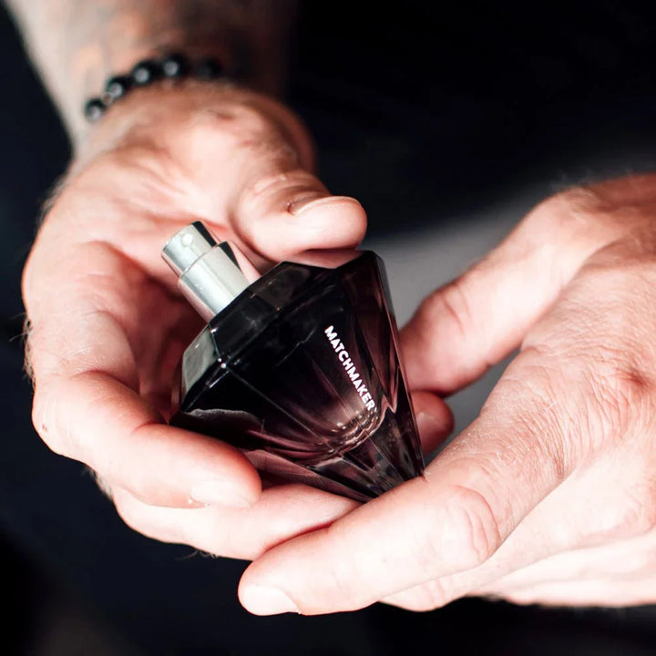 Two hands cradling the Matchmaker Black Diamond bottle in low light