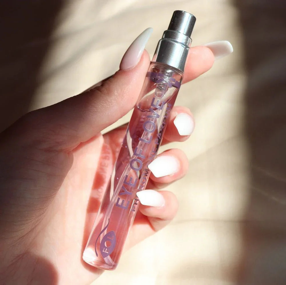 Hand with white nails holding the Morning Glow 10ml vial in bright sunlight