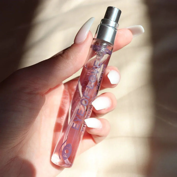 Hand with white nails holding the Morning Glow 10ml vial in bright sunlight