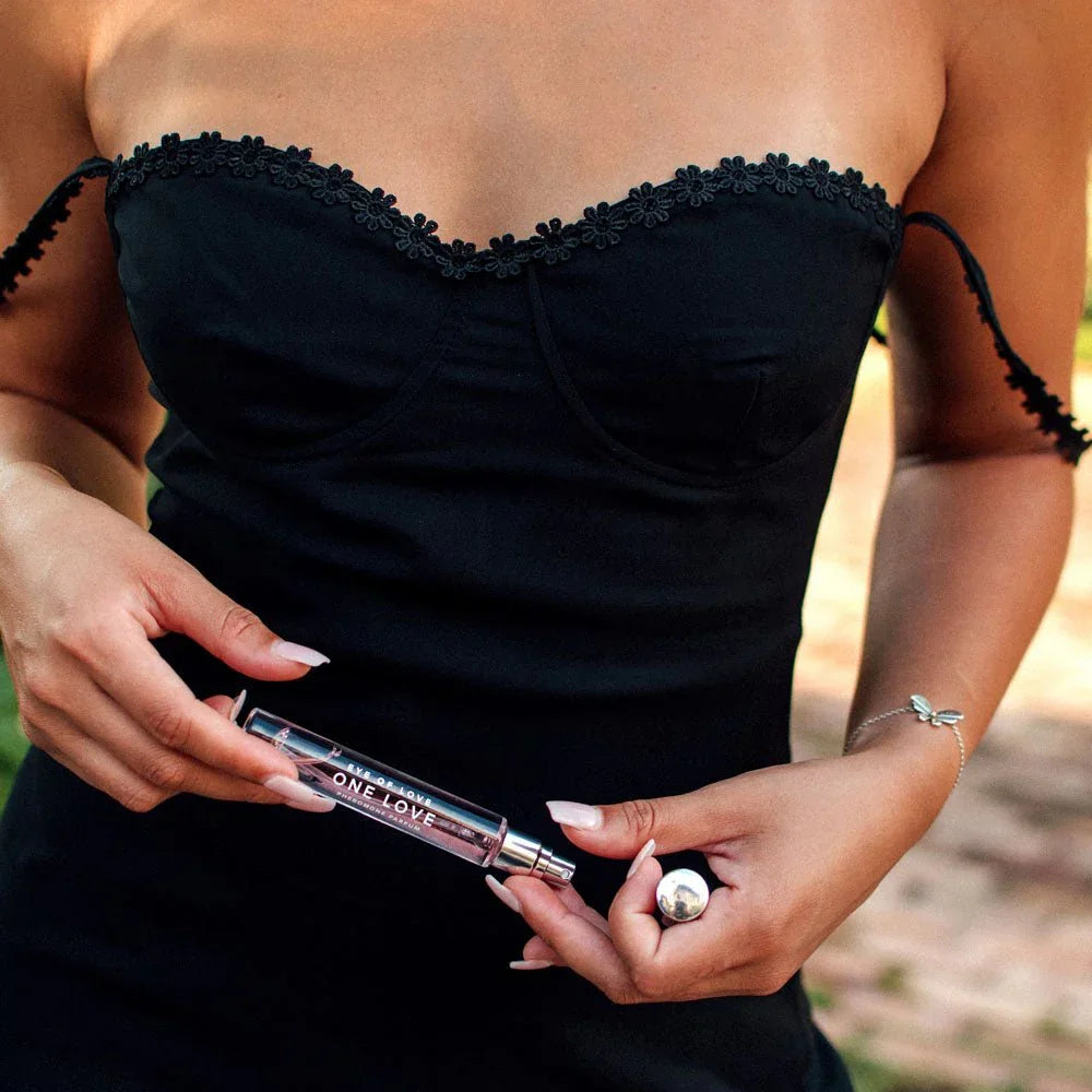 Close-up of hands holding the One Love 10ml vial in front of a black dress
