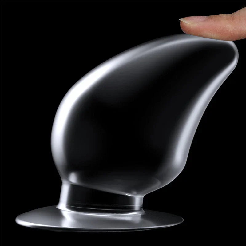 A fingertip tilting the Flawless Clear anal plug on its base to show the flexible neck