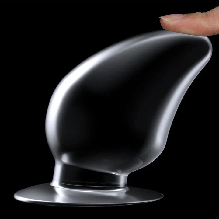 A fingertip tilting the Flawless Clear anal plug on its base to show the flexible neck