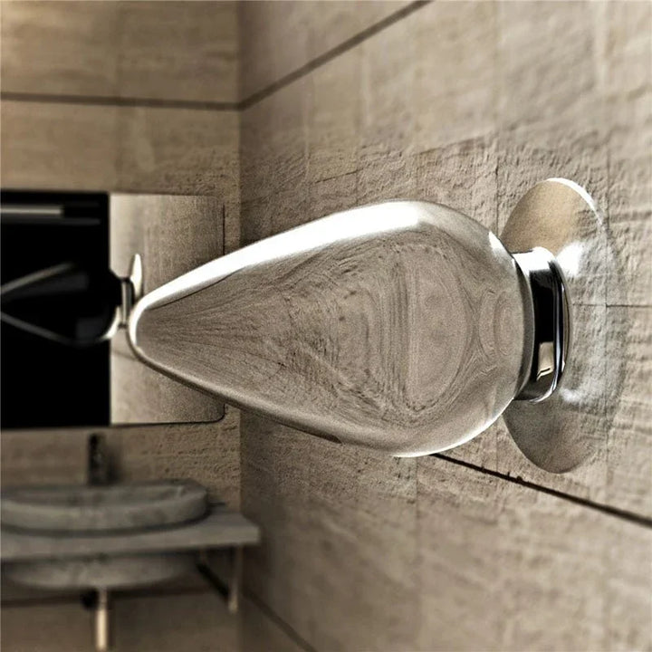 Flawless Clear anal plug suction-mounted on a tiled bathroom wall above a basin