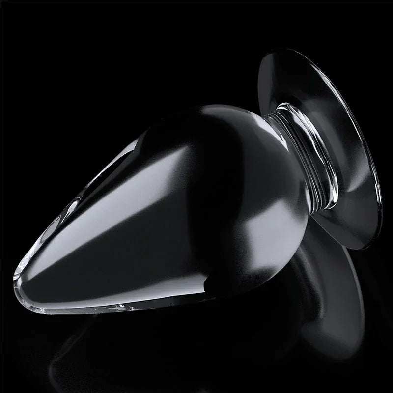 Flawless Clear anal plug tipped at an angle, light catching the transparent tapered body