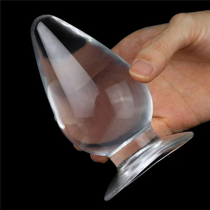 Flawless Clear anal plug held in a hand, seen through the transparent body, for scale