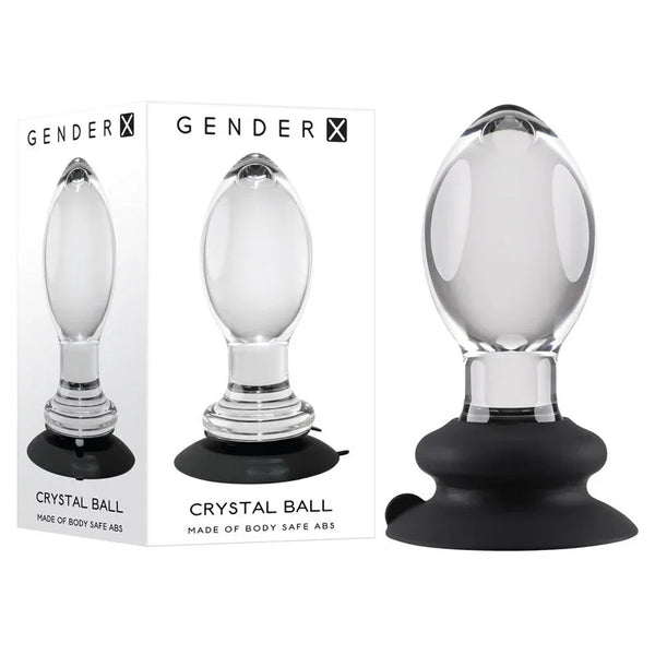 Gender X Crystal Ball clear butt plug on its black suction base, beside the retail box