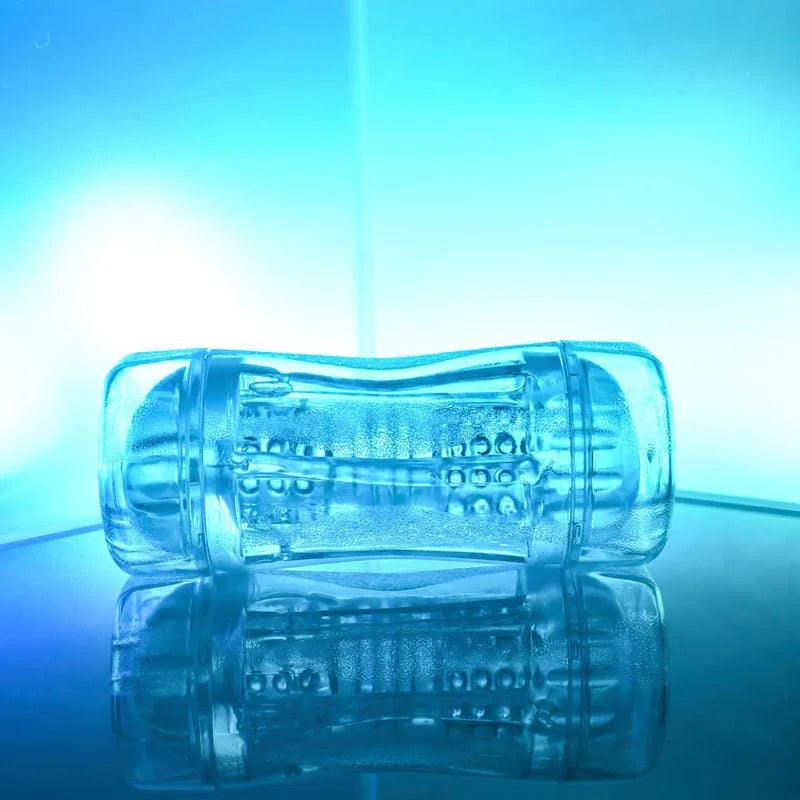 Gender X Double Fantasy stroker in Clear lying flat, beaded inner channel visible