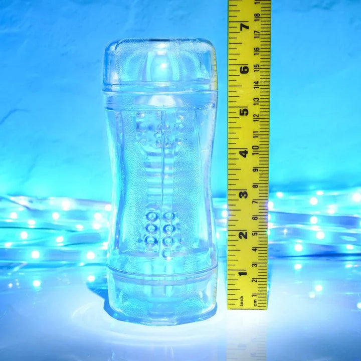 Gender X Double Fantasy stroker in Clear upright beside a tape measure for scale