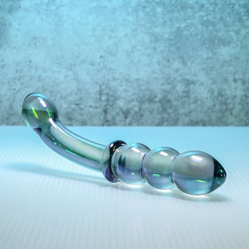 Gender X Lustrous Galaxy Wand on a white ledge against concrete, beaded end forward