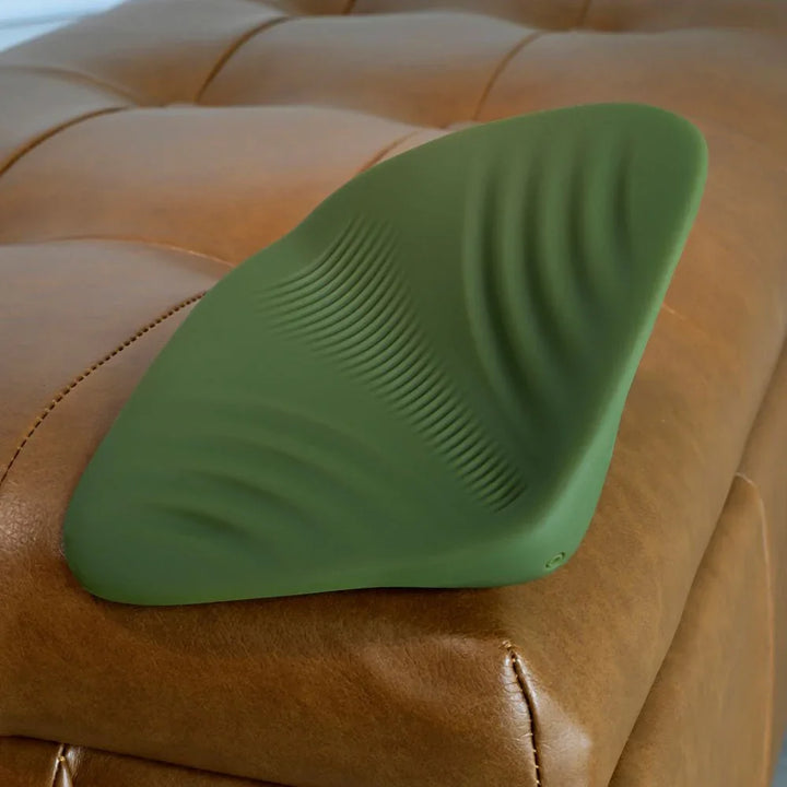 Gender X Pleasure Pad in Green tilted on the ottoman edge, three-quarter view