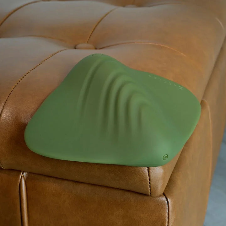 Gender X Pleasure Pad in Green on a tan leather ottoman, ridged top surface