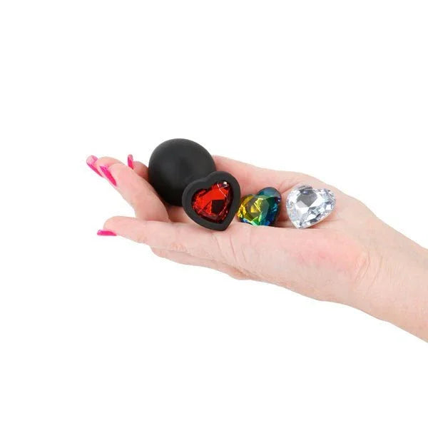 Glams Xchange Heart plug in Black held in a palm with its red, rainbow and clear heart gems