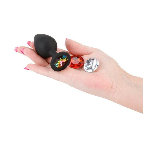 Glams Xchange Round plug in Black held in a palm with its rainbow, red and clear round gems