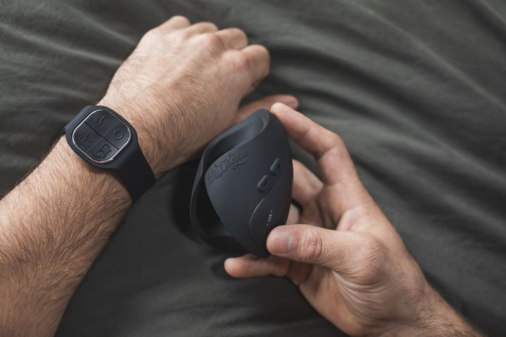 Hot Octopuss Pulse Solo Lux held in a hand, wrist remote worn on the other arm