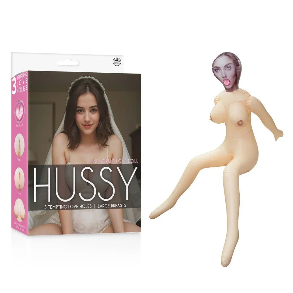 Hussy Gwen inflatable doll posed with one leg raised, beside her pink box