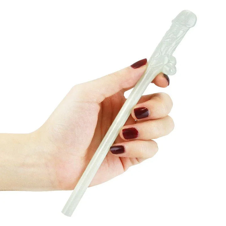 Hand holding one glow in the dark willy straw horizontally to show the moulded shape