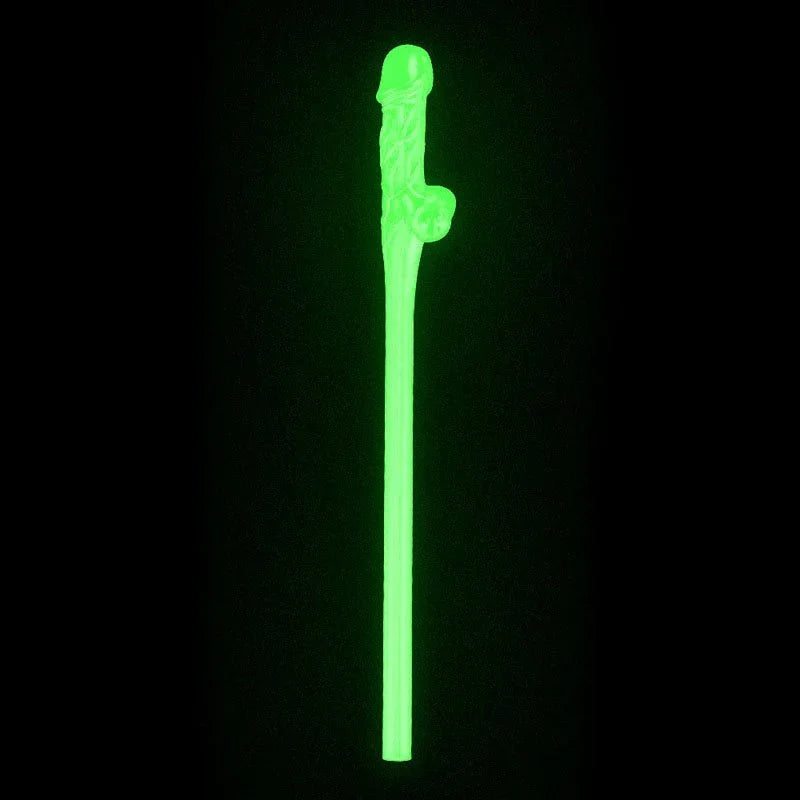 A single willy straw glowing bright green in the dark against a black background