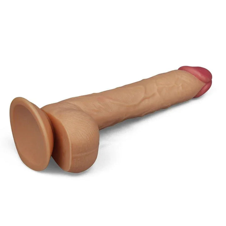 King Size 10 inch dildo lying on white, viewed from behind the round suction cup