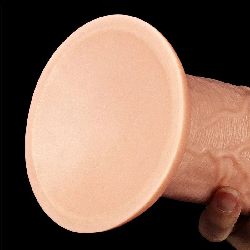 Underside of the King Size 11 inch dildo's wide flat suction cup, held against black