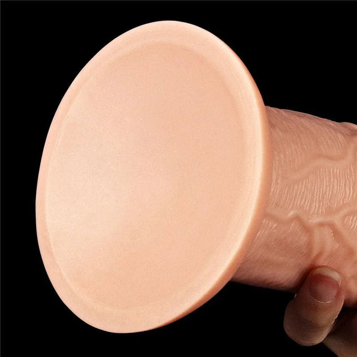 Underside of the King Size 11 inch dildo's wide flat suction cup, held against black