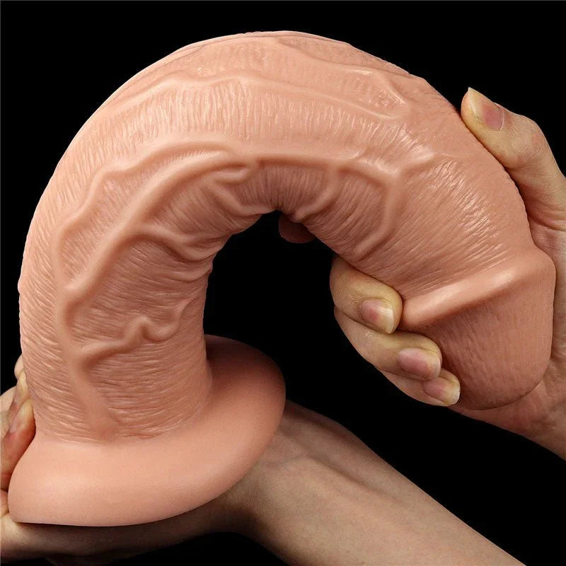 King Size 11 inch dildo bent right over into a horseshoe by a hand at the base