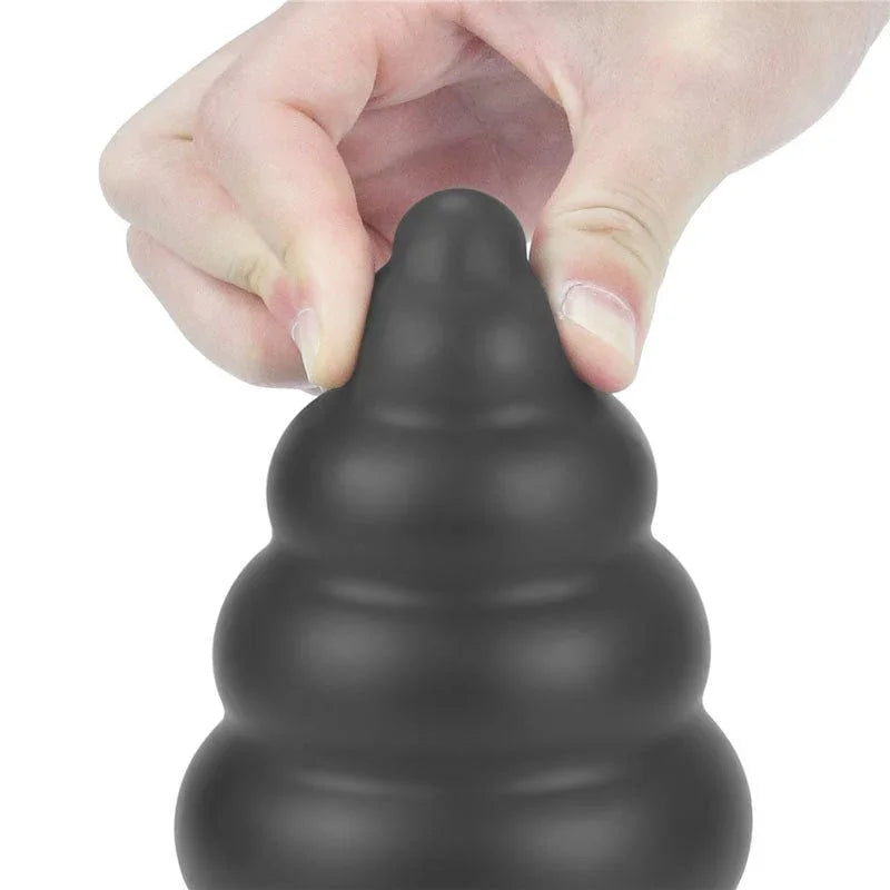 Fingers pinching the tapered tip of the black Anal Cracker to show the soft silicone