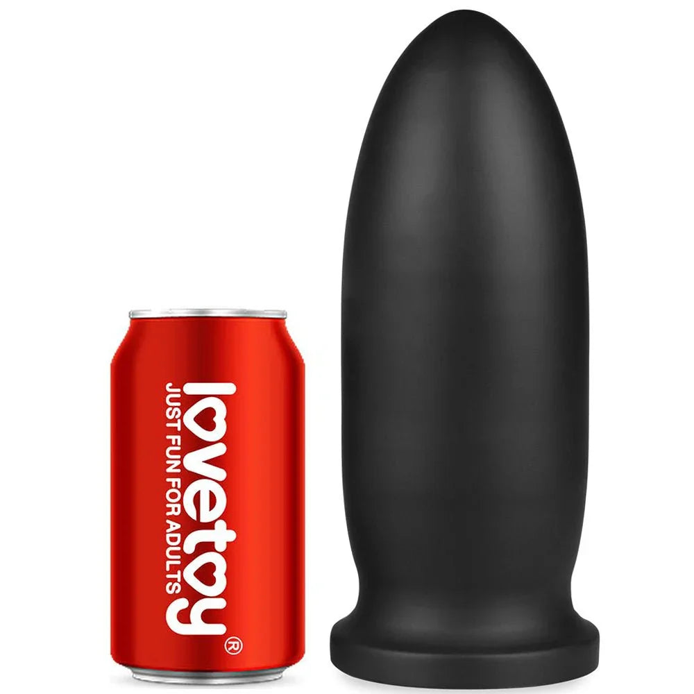 Black Anal Bomber mega plug standing next to a soft drink can for scale