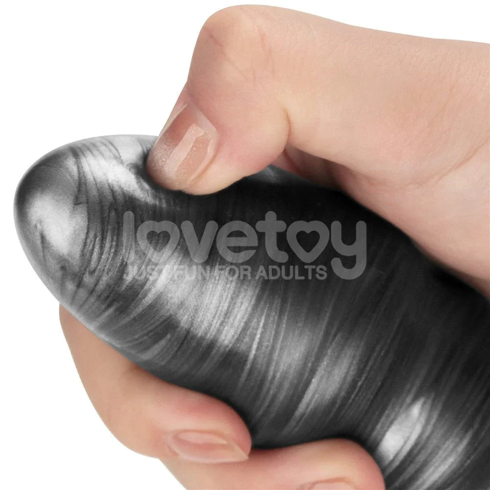 Hand squeezing the grey marbled shaft of the Vibrax Slider to show the soft silicone