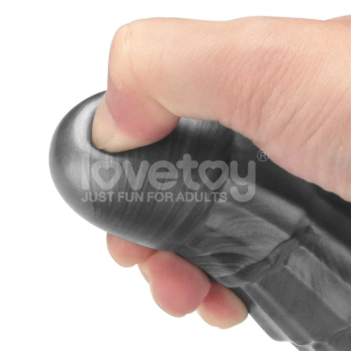 Hand squeezing the smooth grey head of the Vibrax Slider 14.5 inch