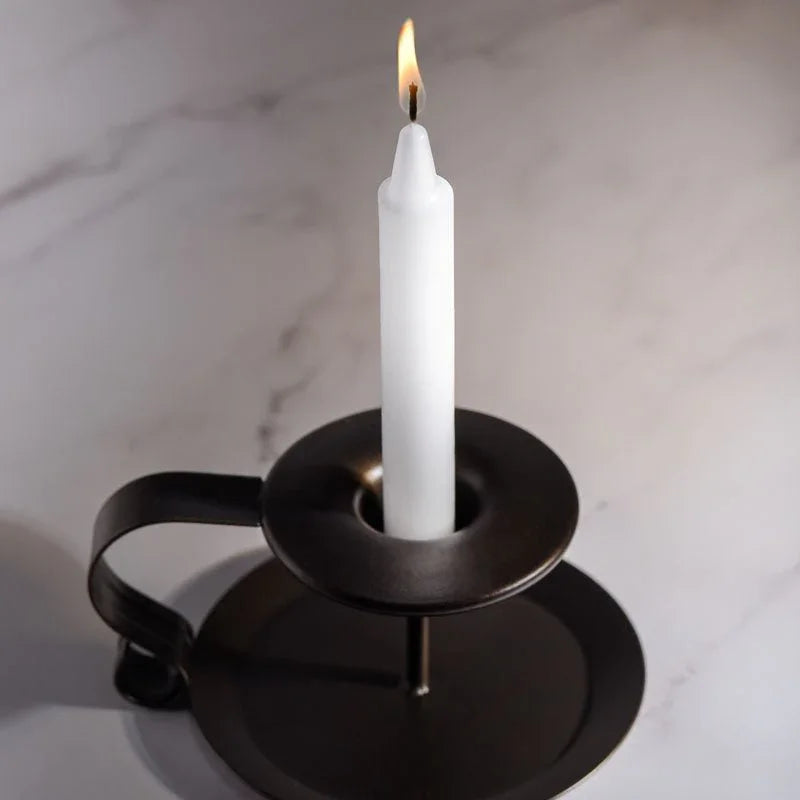 LaCire white drip candle burning in a metal holder on marble